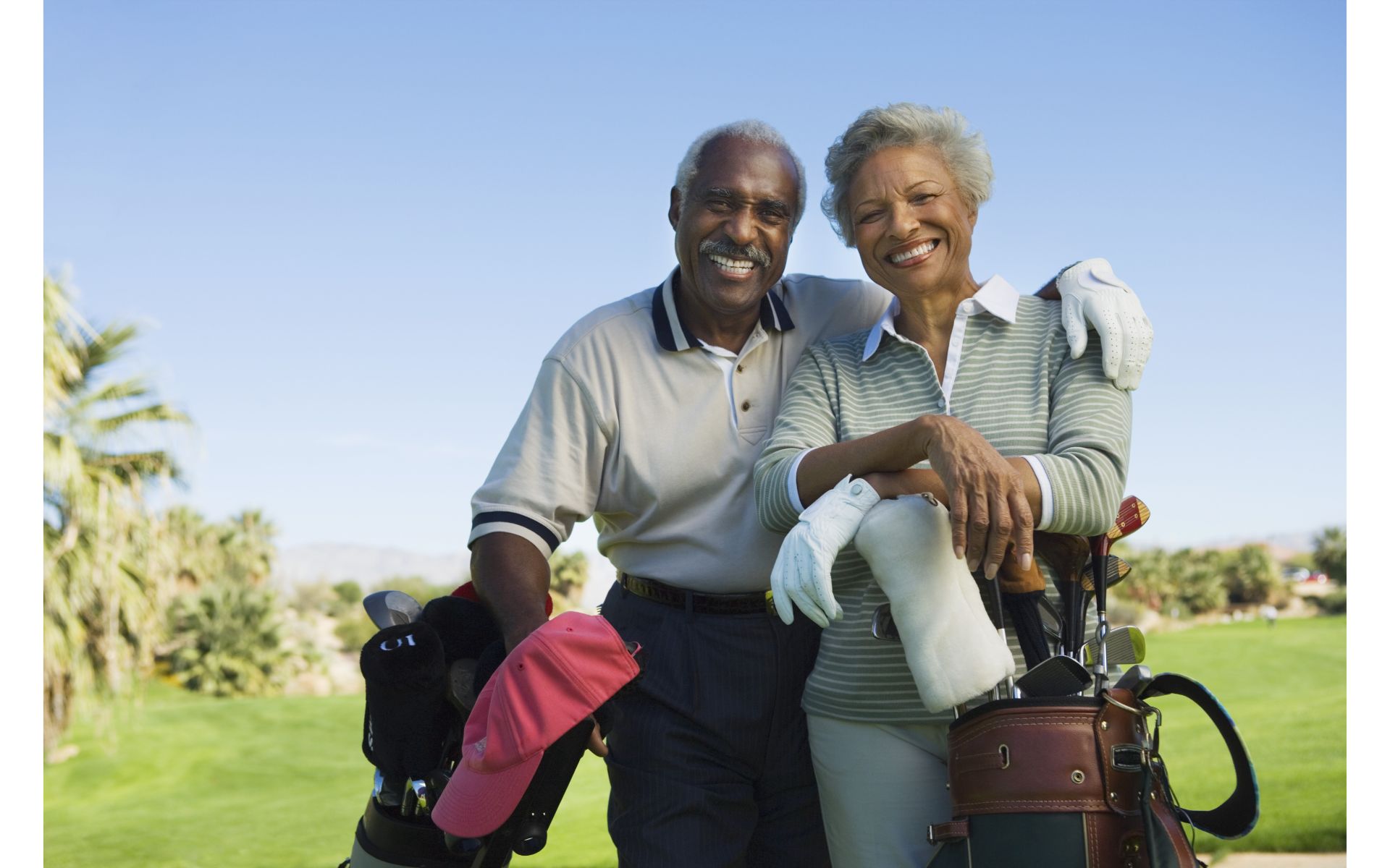 Older couple on golf course together. Article about adapting to changes in mobility.