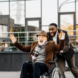 Older man being pushed in wheelchair.