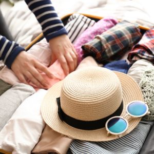 A woman packing a suitcase. Article about taking a vacation as a caretaker.