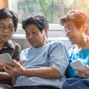 Three older women looking at touchscreen devices. Cover image for article about geotracking.