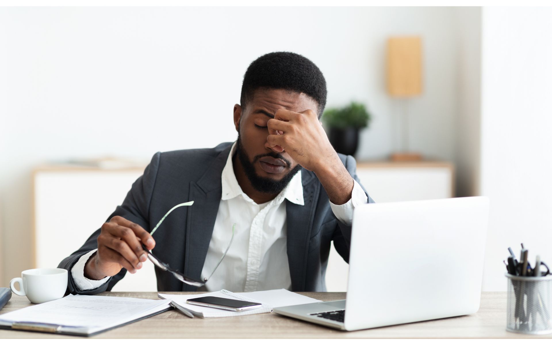 A frustrated man sits in front of the computer. Cover image for an article on managing career and caretaking.