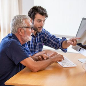 An elderly man and his son discuss internet findings.