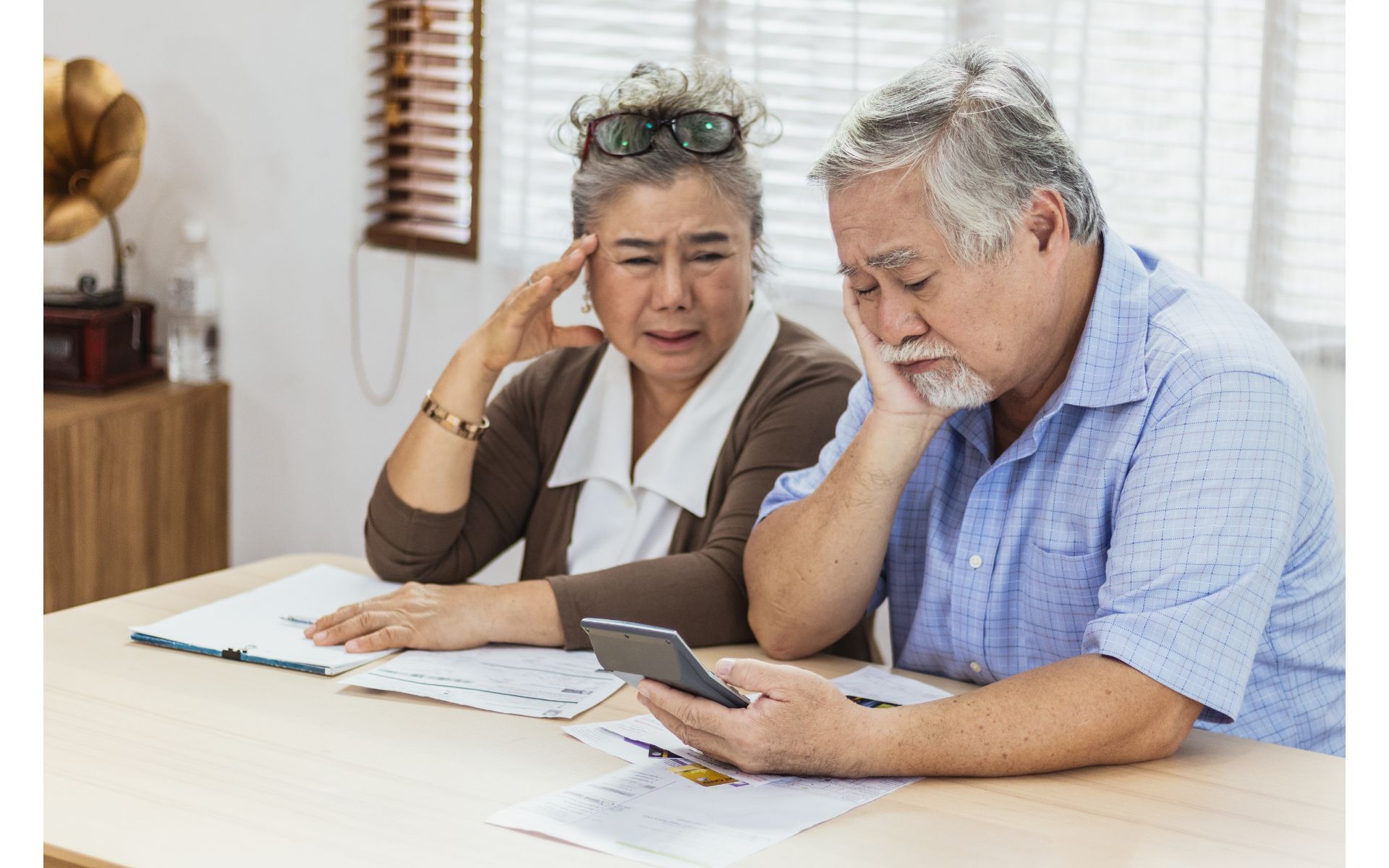 Older couple looking stressed while reviewing financial documents.
