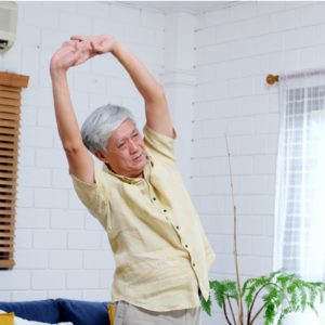 An older woman exercising at home.