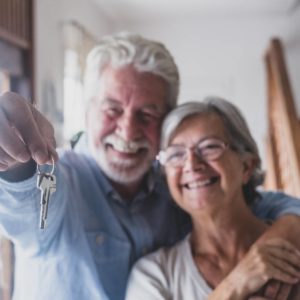 Older couple holding keys. Cover image for article about garage modifications for seniors.