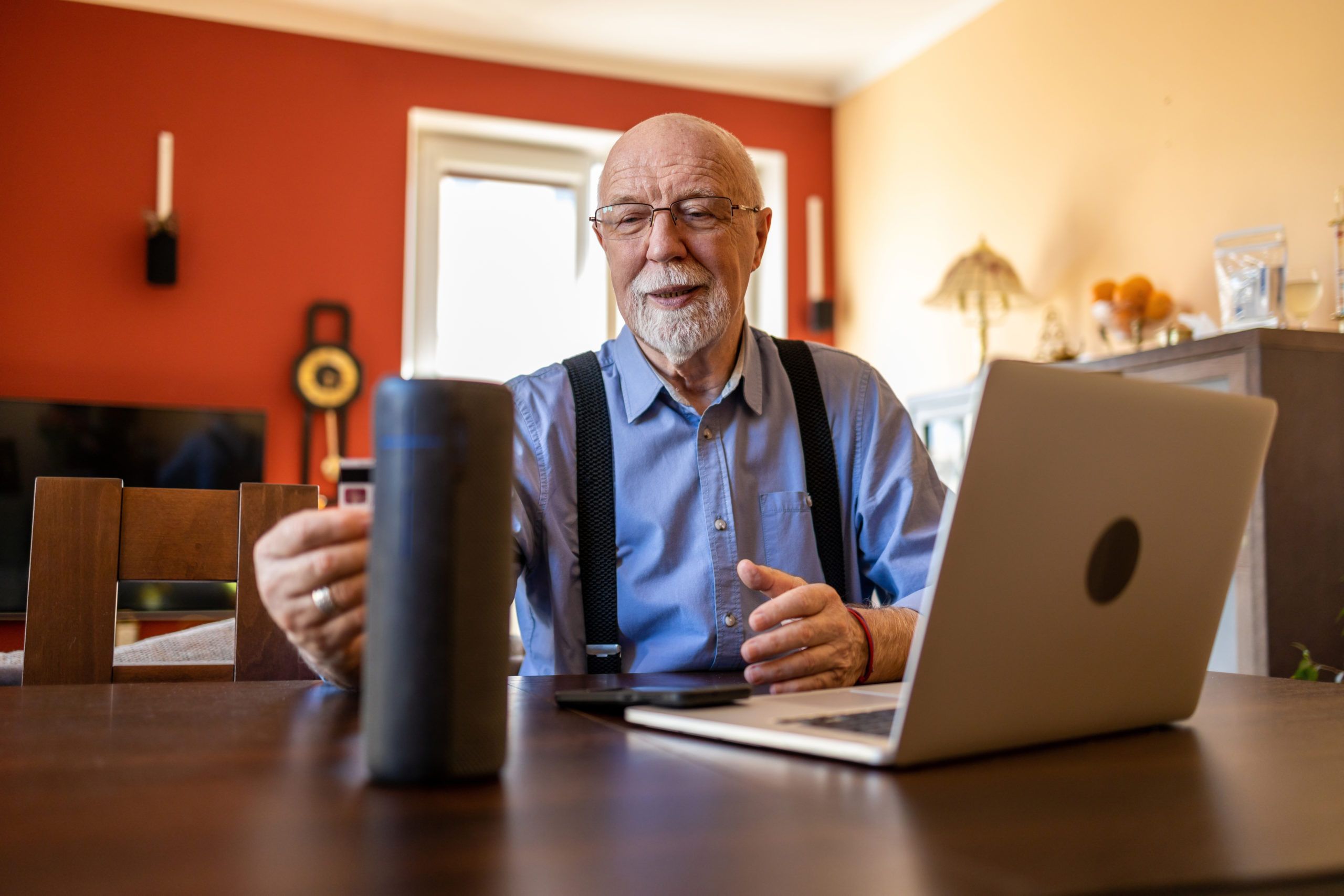 Older man at computer holding coffee mug. Cover image for article about communicating care using technology.