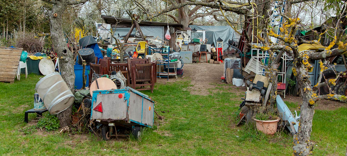 Yard filled with various items. Cover image for article about Hoarding Disorder in Older Adults.