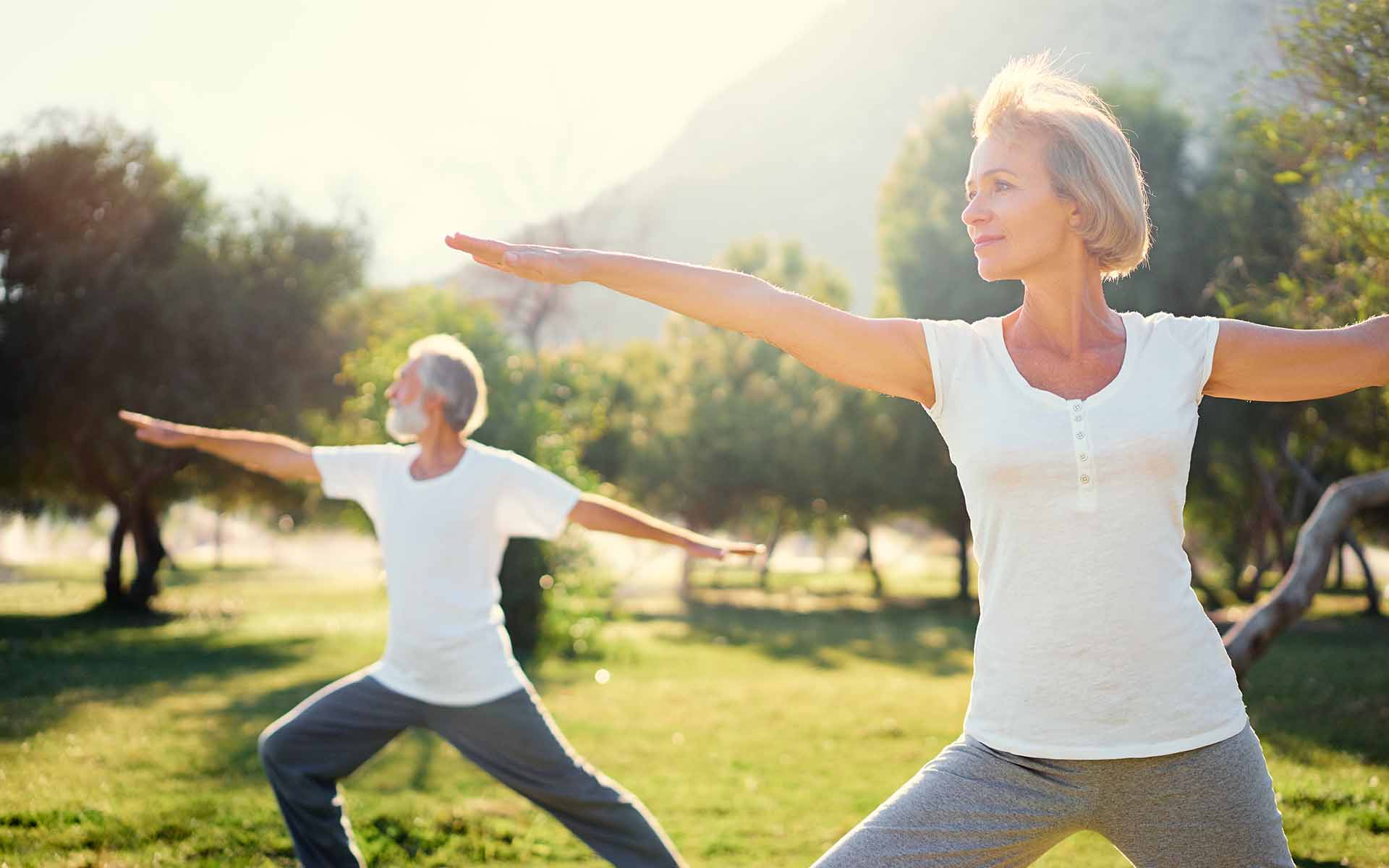 Senior family doing yoga exercises outside. Cover image for article about exercises for seniors.
