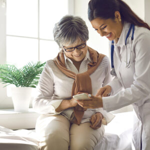 Senior reviewing health tracking device with medical professional