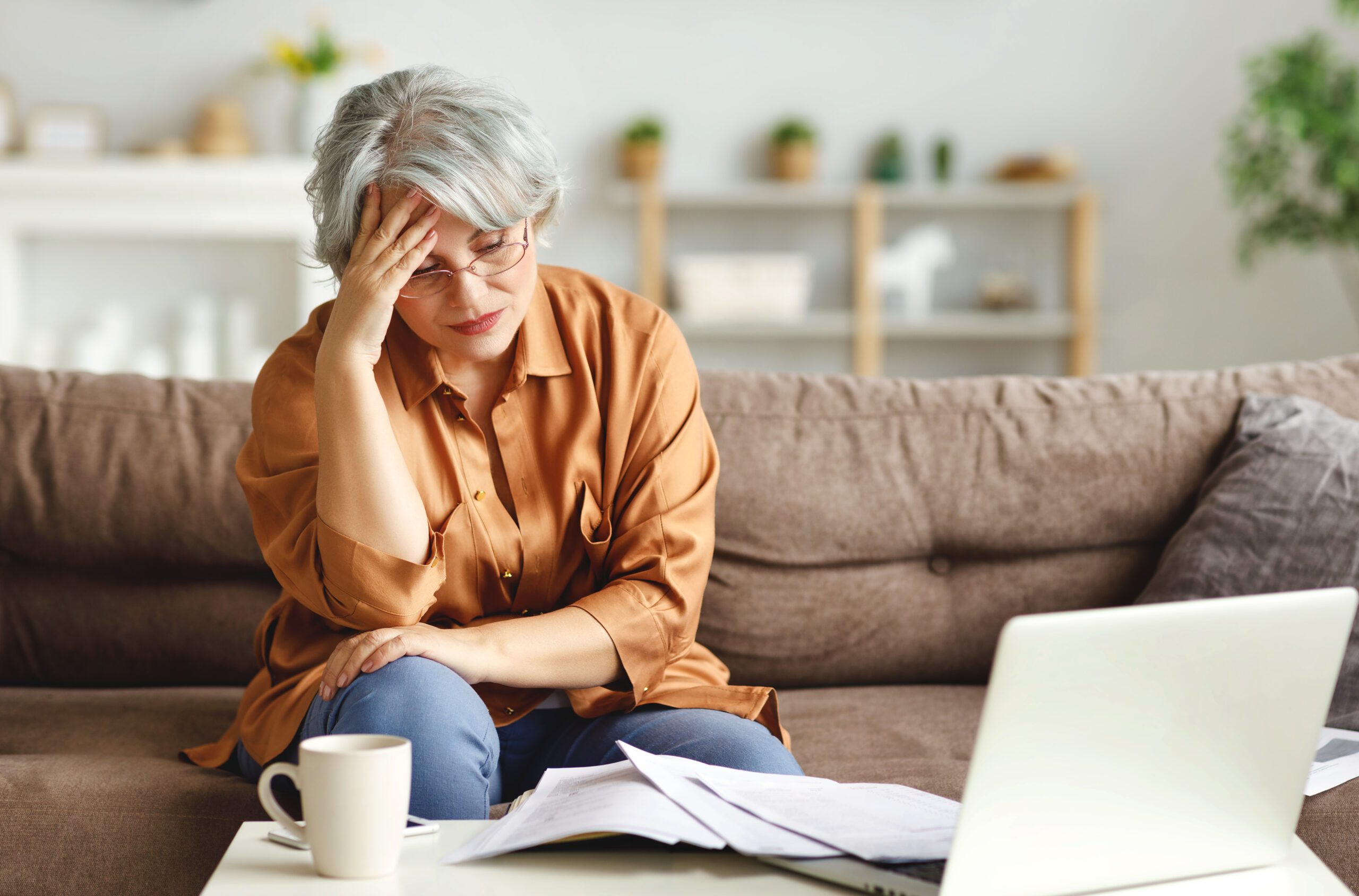 A senior overwhelmed by finances, a feeling that can be reduced with proper stress reduction strategies.